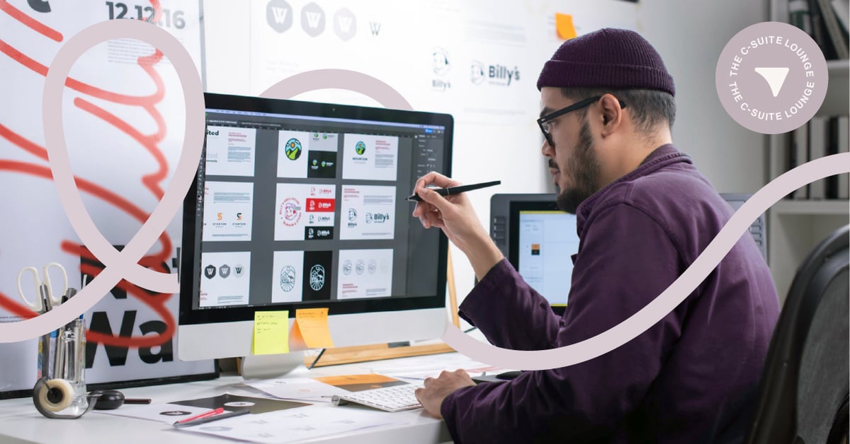 Creative designer sits at computer with stylus in hand pointed at screen