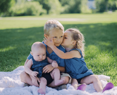 children posing on a picnic blanket