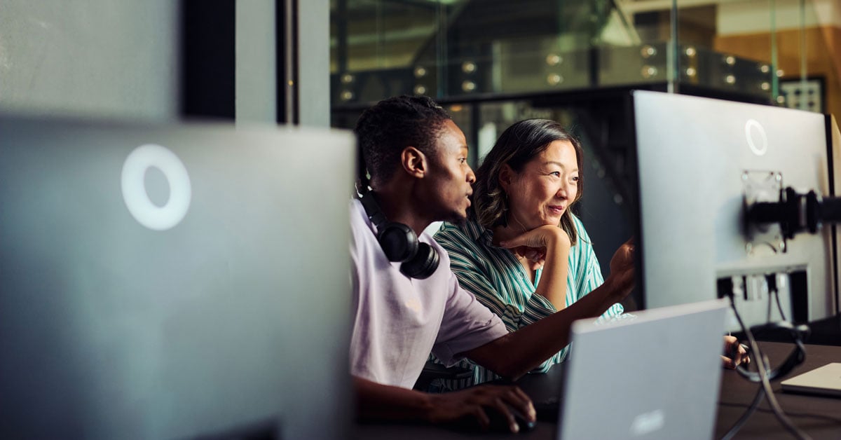 Two website designers working on a computer.