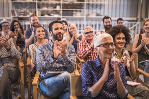 Audience of males and females applauding