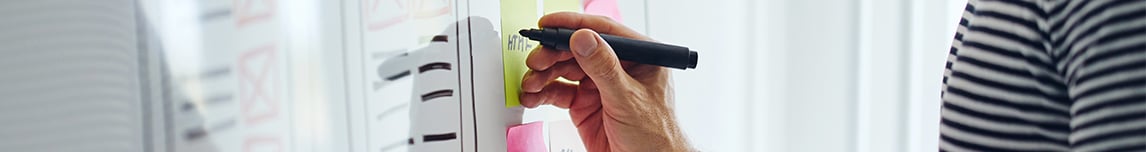 hand-holding-marker-writing-on-white-board