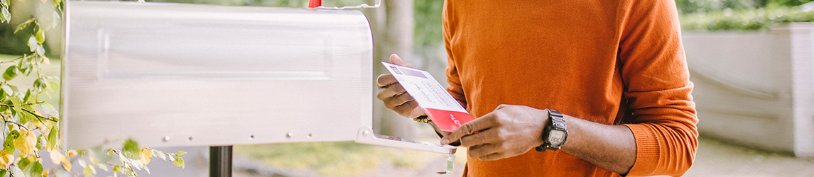 man-looks-at-letter-by-mailbox-1