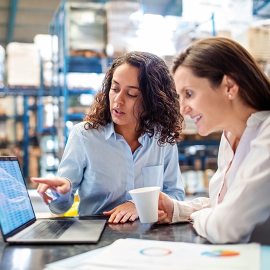 two woman looking at a laptop